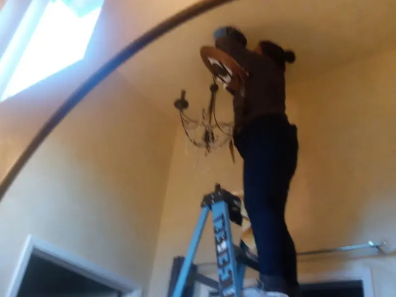Electrician installing a chandelier in a Ogden residence